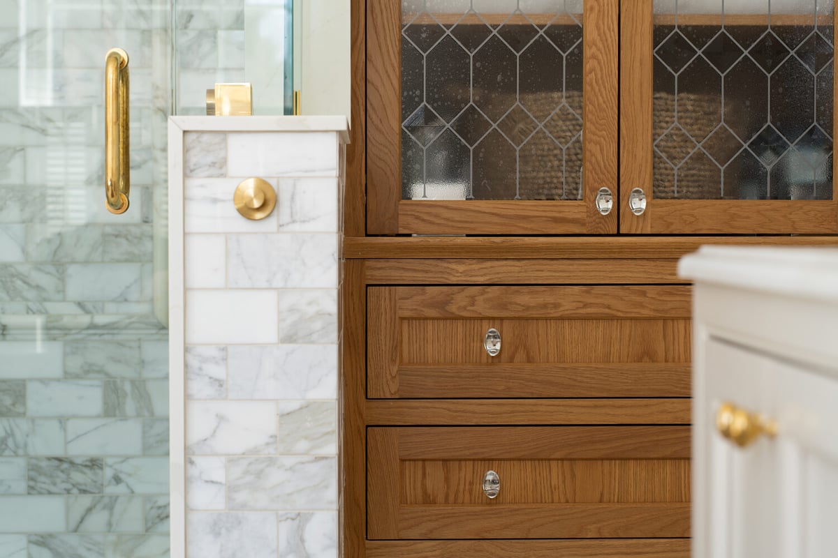 built-in bathroom storage with wood cabinetry and tile shower in custom home by Craft Design + Build in Lyme, CT