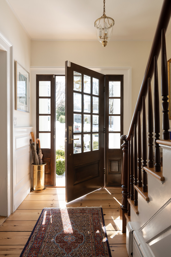 custom home entryway with wood front door and staircase by Craft Design + Build in Old Saybrook, CT