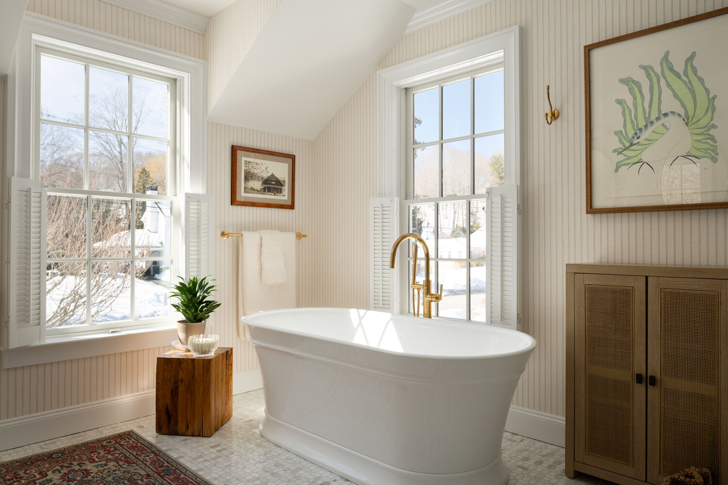 sunlit custom home bathroom with soaking tub and brass hardware by Craft Design + Build in Westbrook, CT