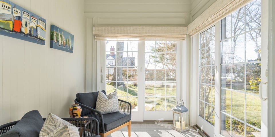 Sunroom addition in Essex, Connecticute with linen blinds, white french doors, and blue chairs