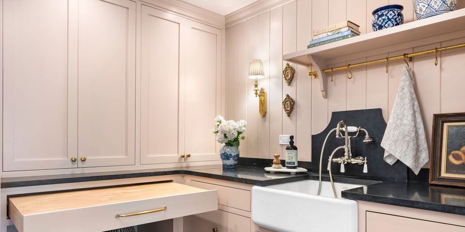 custom laundry room with pink cabinets and gold fixtures on the Connecticut shoreline