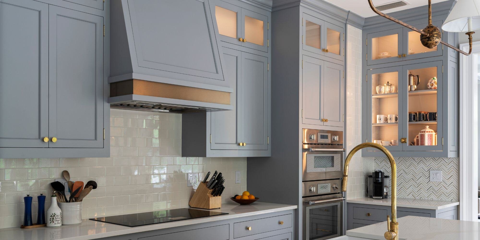 essex connecticut kitchen remodel with blue cabinets, gold fixtures, and custom vent hood