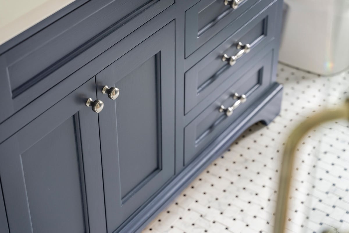 Blue bathroom vanity drawers with polished handles in Essex Primary Bathroom by Craft Design + Build, Essex, Connecticut