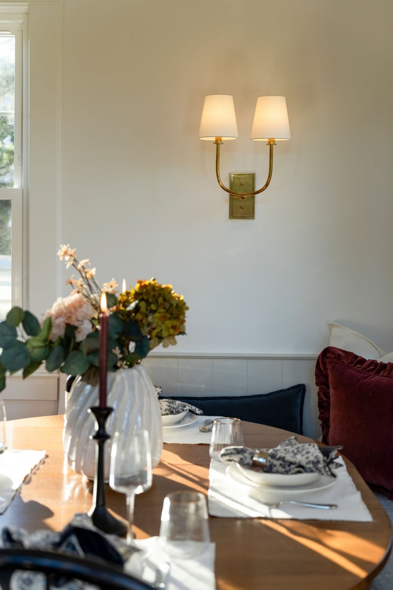 dining table with bench seating and gold wall sconce
