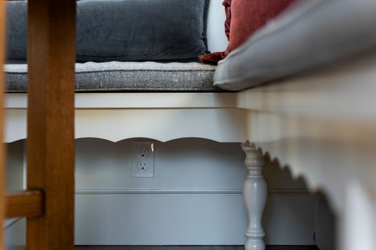 scalloped edge detail on a bench in kitchen dining area with electrical outlet