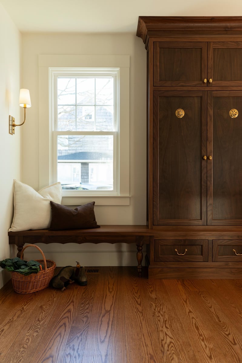 wooden storage unit and bench in a mudroom entryway