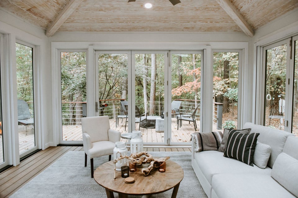 Cozy sunroom with large windows and deck access, designed by Craft Design + Build, Essex, Connecticut
