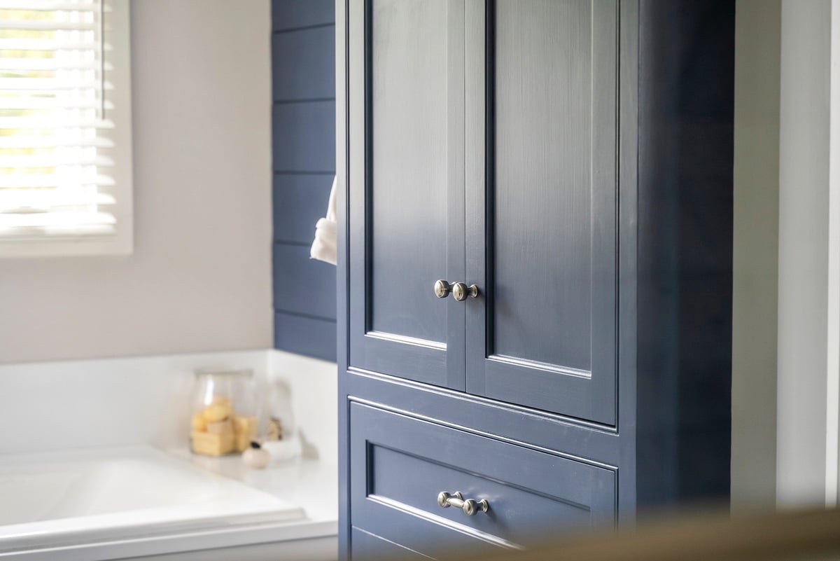 Custom navy blue bathroom cabinetry in Essex Primary Bathroom by Craft Design + Build, Essex, Connecticut