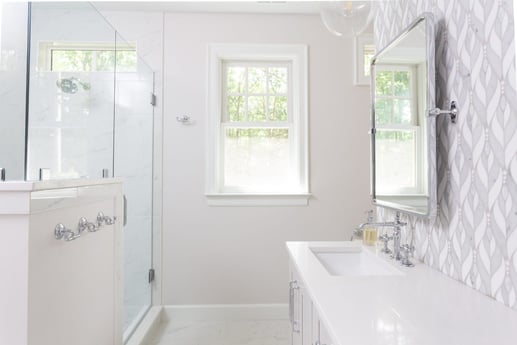 Elegant owners bathroom featuring dual sinks and a stylish patterned backsplash, remodeled by Craft Design + Build in Essex, Connecticut-1