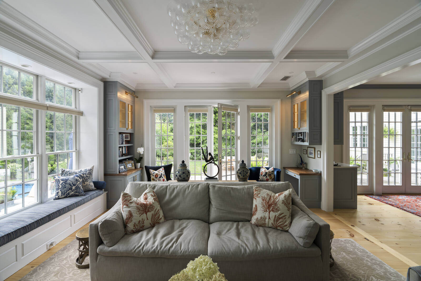 Modern living room with large windows and a cozy sofa, designed by Craft Design and Build in Essex, Connecticut Modern living room with large windows and a cozy sofa, designed by Craft Design and Build in Essex, Connecticut