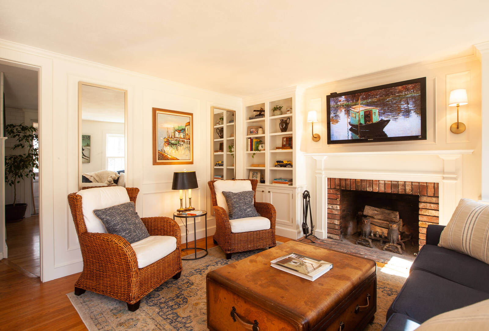 Living room with wicker chairs and fireplace by Craft Design and Build, Essex, Connecticut