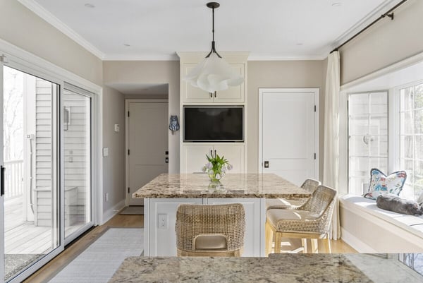 Bright kitchen nook with island seating and large windows by Craft Design Build in Essex, CT