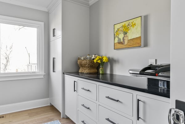 Contemporary laundry room with white cabinetry and daffodil accents by Craft Design Build in Essex, CT