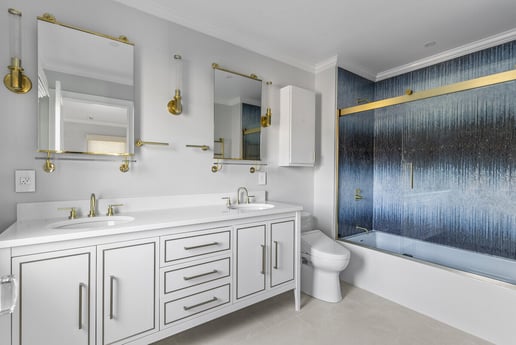 Modern bathroom with dual sinks and gold fixtures by Craft Design Build in Essex, CT