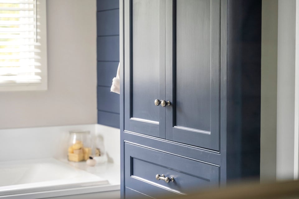Navy bathroom cabinet in a custom home remodel by Craft Design Build, Essex, CT