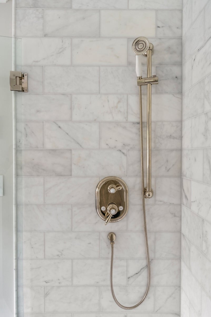 Luxurious marble and brass shower in Essex Primary Bathroom by Craft Design + Build, Essex, Connecticut