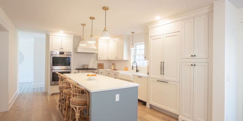 Traditional kitchen remodel in Essex, Connecticut with white cabinets, black hardware, and a kitchen island with stool seating