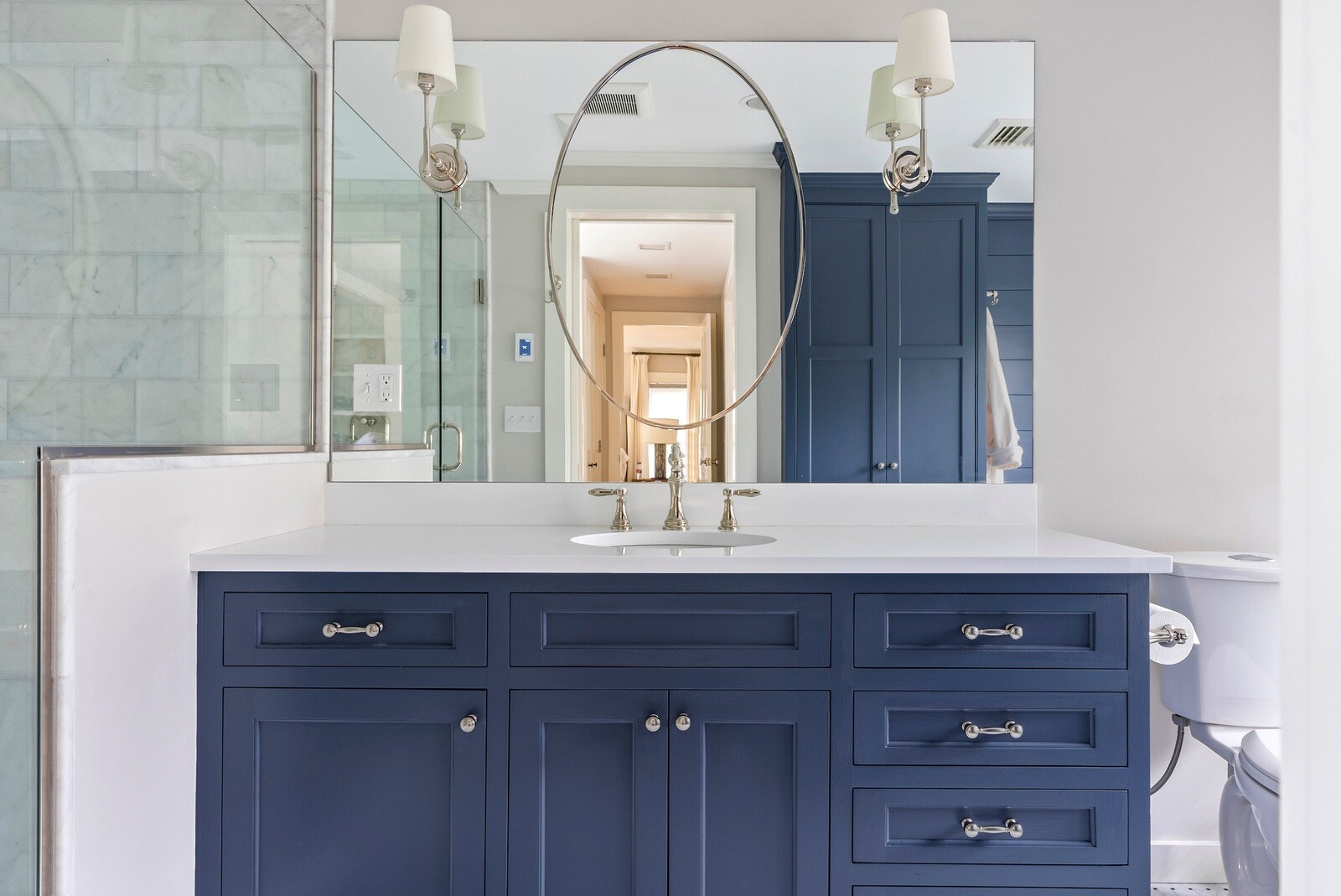 White double sink vanity with oval mirror in Essex Primary Bathroom by Craft Design + Build, Essex, Connecticut