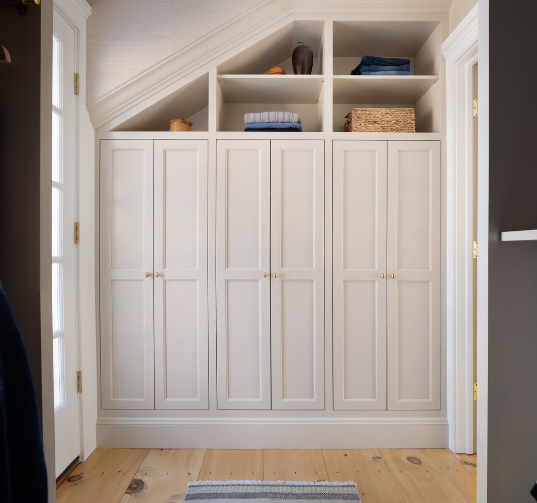 built-in wardrobe storage with cabinetry and shelving in custom home by Craft Design + Build in North Madison, CT