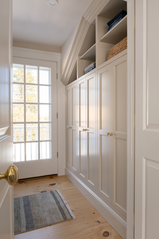 custom closet with paneled doors and open shelving in home by Craft Design + Build in Niantic, CT