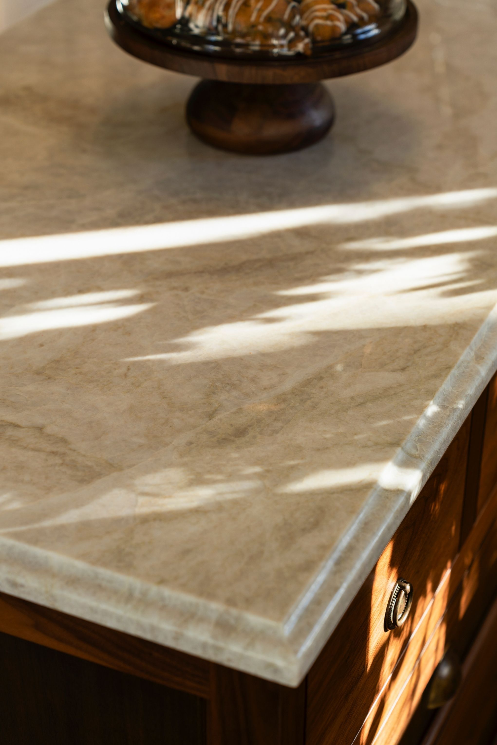 marble countertops on a wooden kitchen island in a traditional kitchen