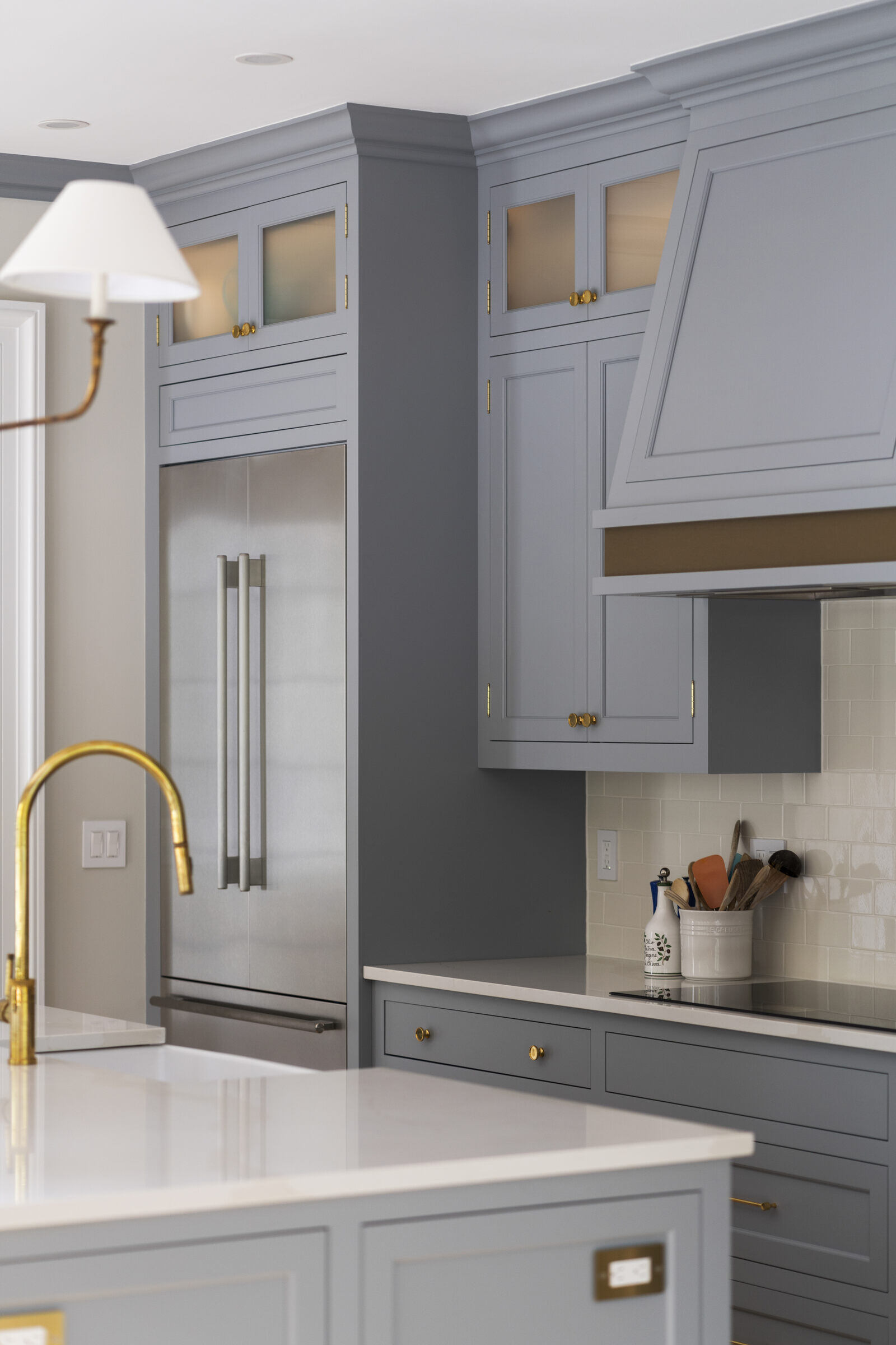 Modern kitchen with grey cabinets and a gold faucet by Craft Design and Build in Essex, Connecticut