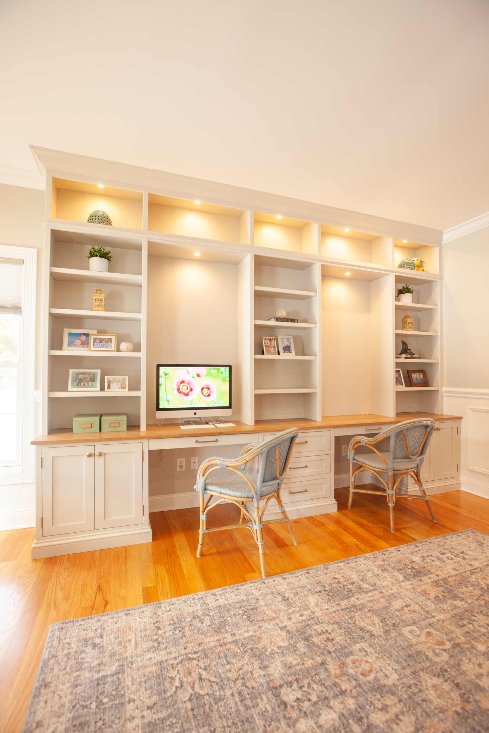 Bright home office with built-in desk and shelves by Craft Design and Build in Essex, Connecticut