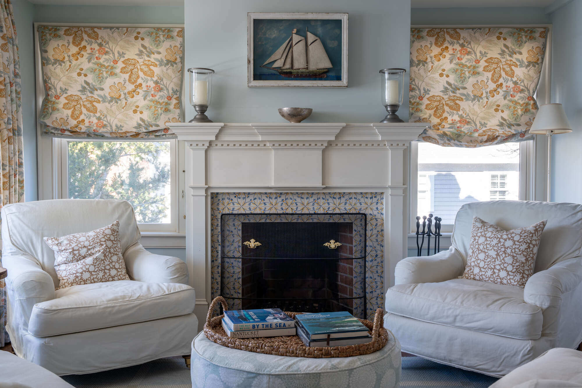 Cozy living room with fireplace and floral curtains by Craft Design Build in Essex, CT