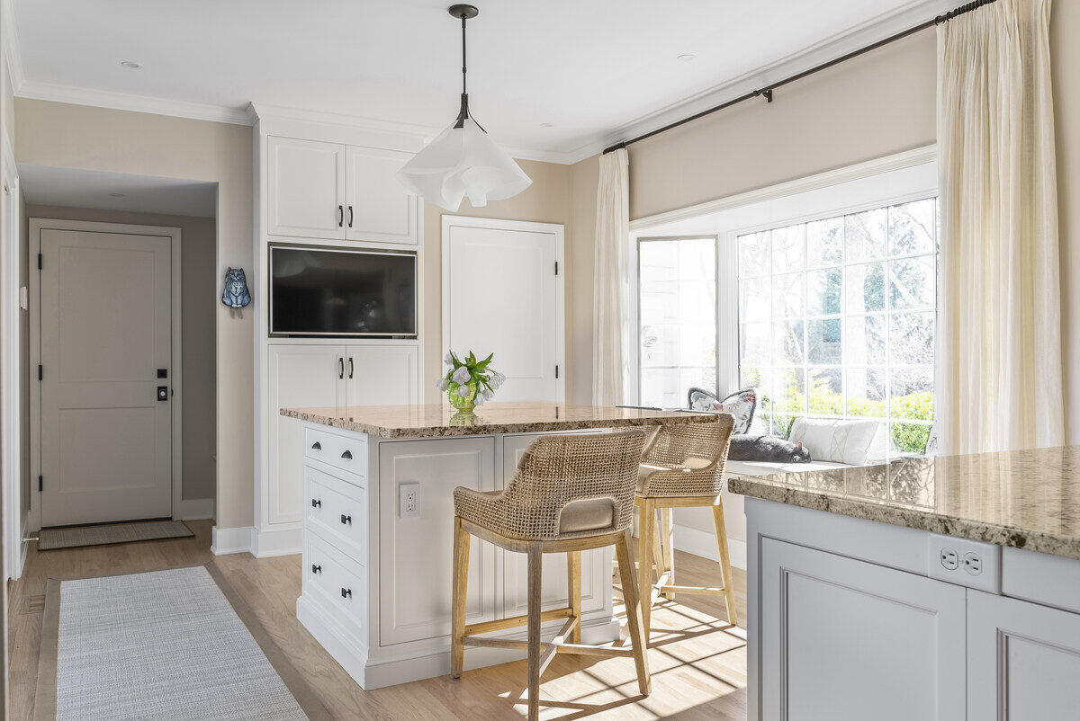 Bright kitchen nook with island seating and large window by Craft Design Build in Essex, CT