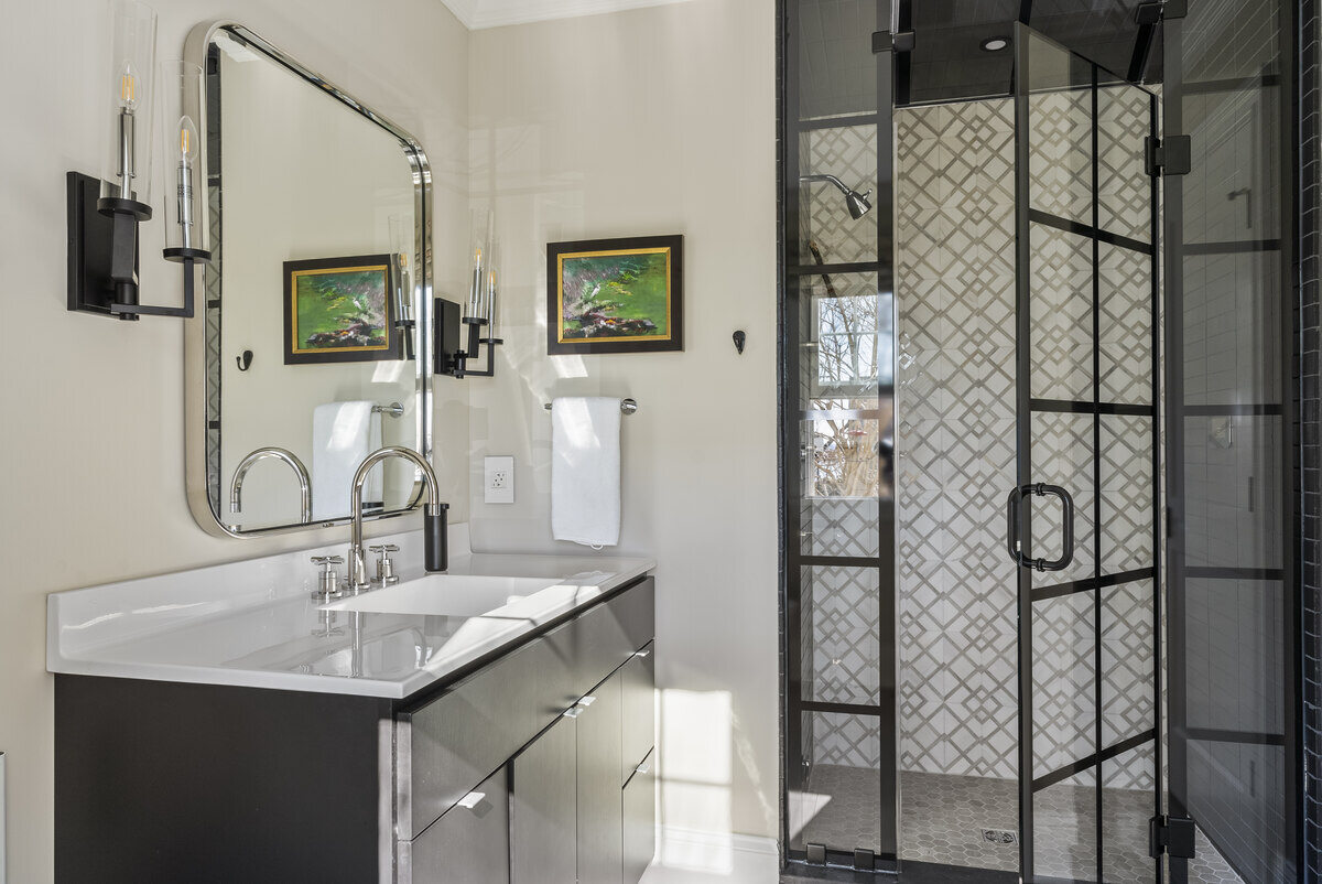 Elegant bathroom remodel by Craft Design Build in Essex, CT with black vanity and modern shower