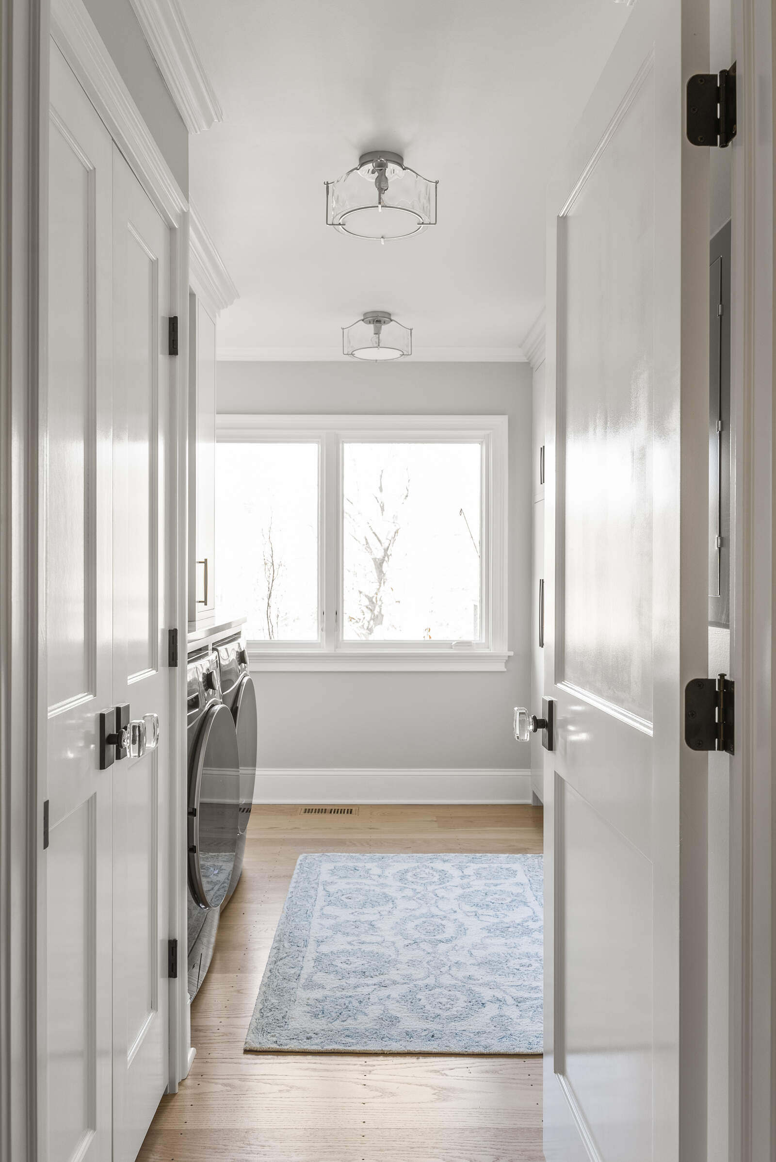 Bright laundry room with washer and dryer by Craft Design Build in Essex, CT