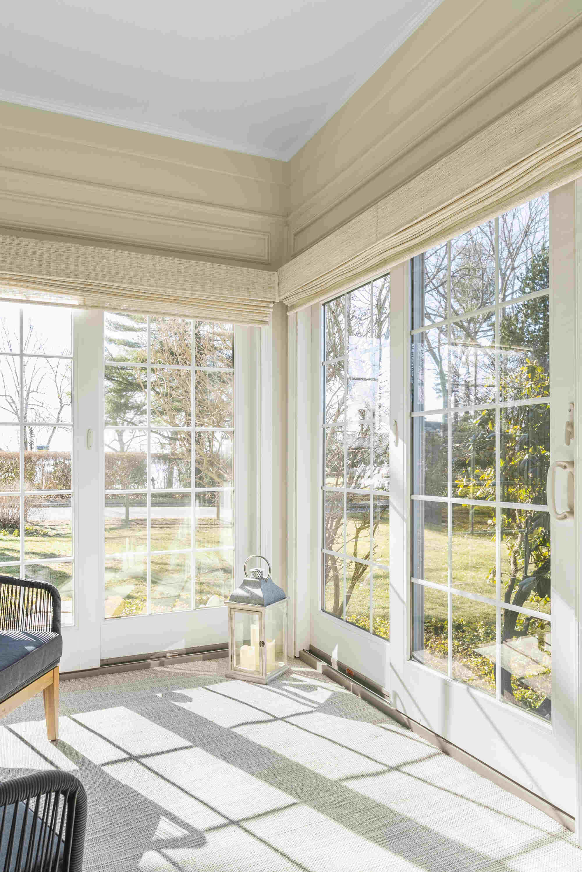 Bright sunroom with black chairs and large windows by Craft Design Build in Essex, CT