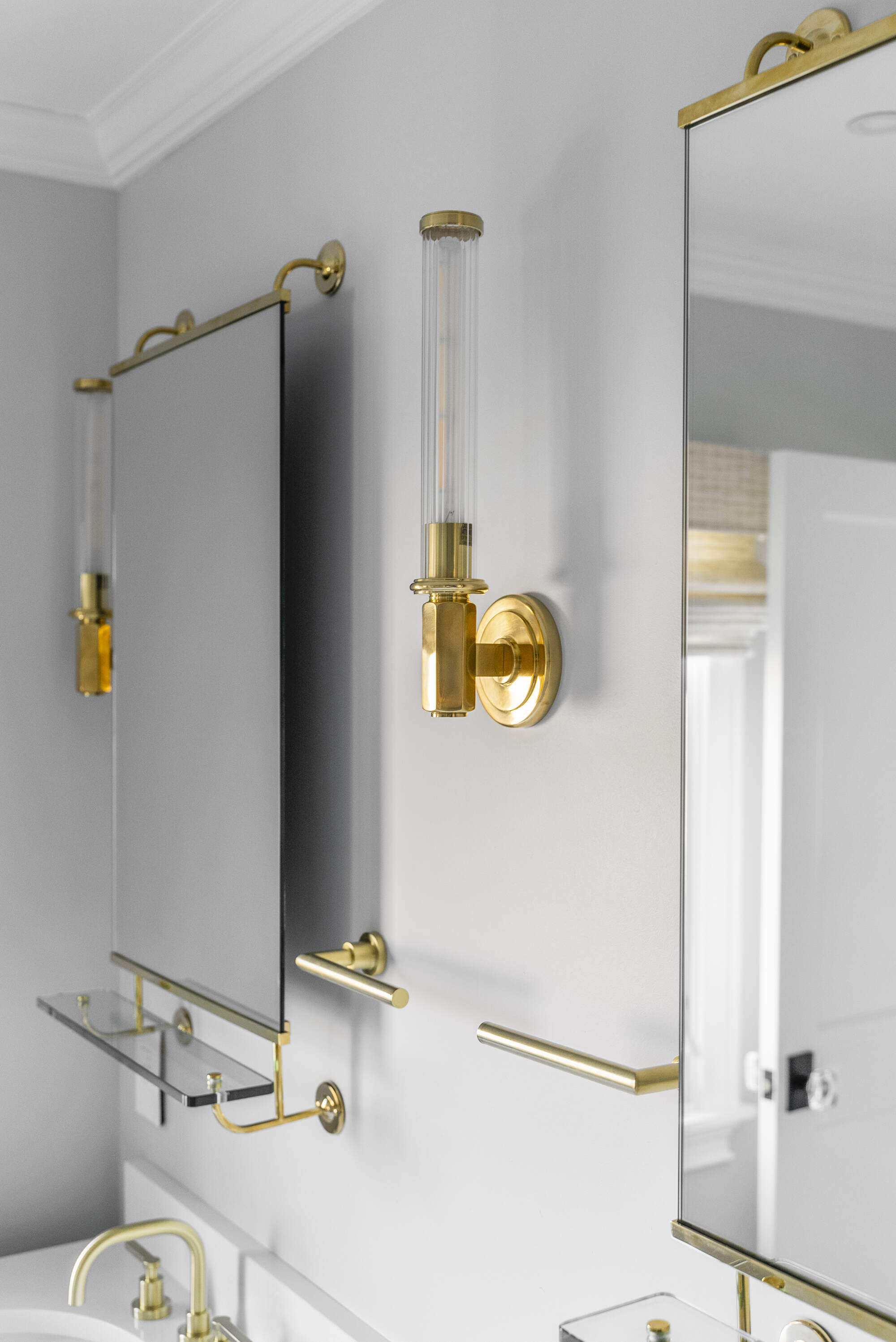 Stylish bathroom vanity with gold accents and mirror in Essex, CT by Craft Design Build